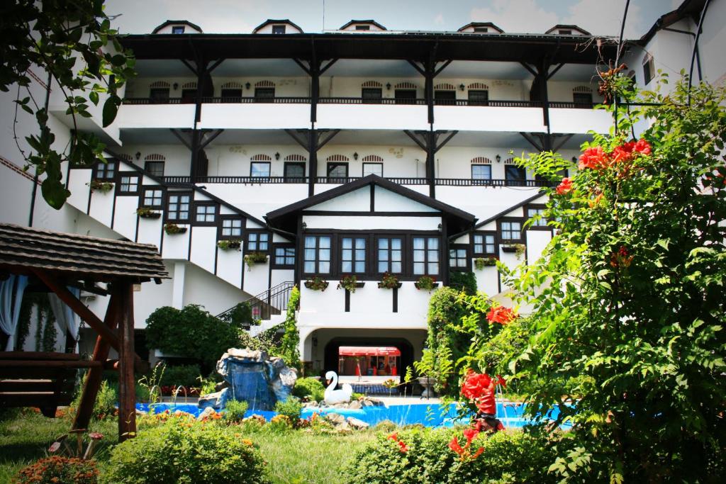 a building with a swimming pool in front of it at Complex Turistic "Moara Dragaicilor" in Buzau