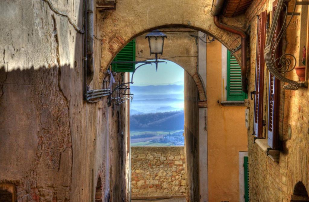 un callejón con un arco entre dos edificios en La Casa del Buonumore, en Montepulciano