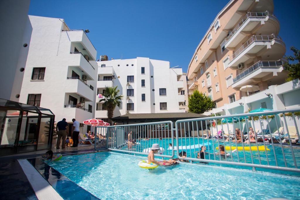 a group of people in a swimming pool next to buildings at Tuntas Suites Altinkum in Didim