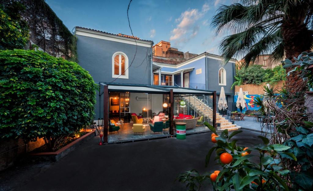 a house with a large glass extension in front of it at The Yard Hostel in Catania