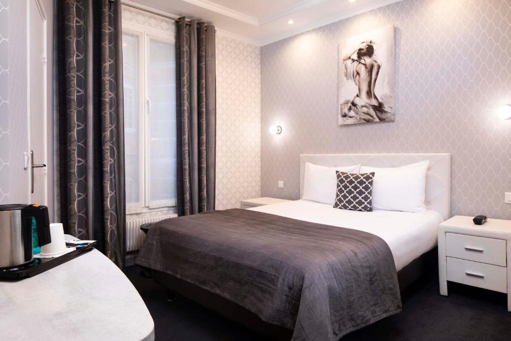 パリにあるホテル ドゥ ジュネーブのベッド付きの客室で、壁に絵が描かれています。