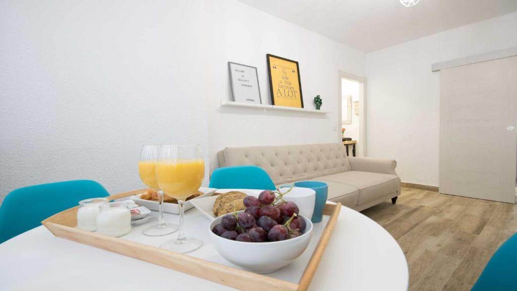 uma mesa com uma taça de fruta e um copo de sumo de laranja em Apartamento Realejo 2 Habitaciones em Córdoba
