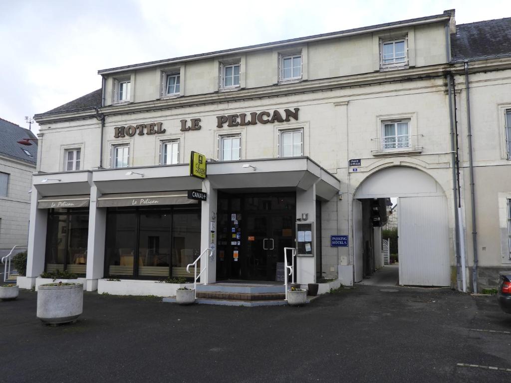 un gran edificio blanco con un letrero que lee hotel n caído en logis le pélican hotel restaurant en Vernantes