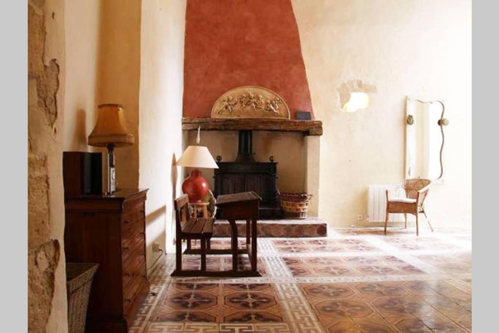 FranquevauxにあるAncienne Abbaye de Franquevaux Templiersの暖炉とテーブルのあるリビングルーム