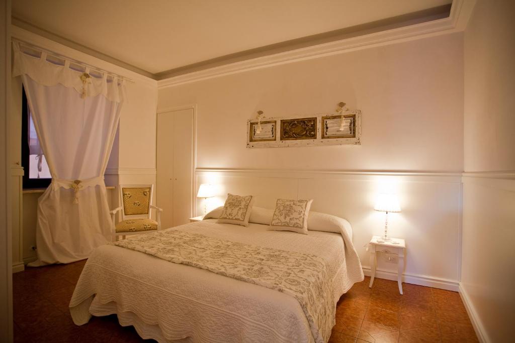 een witte slaapkamer met een bed en een raam bij Antica Riva in Verona