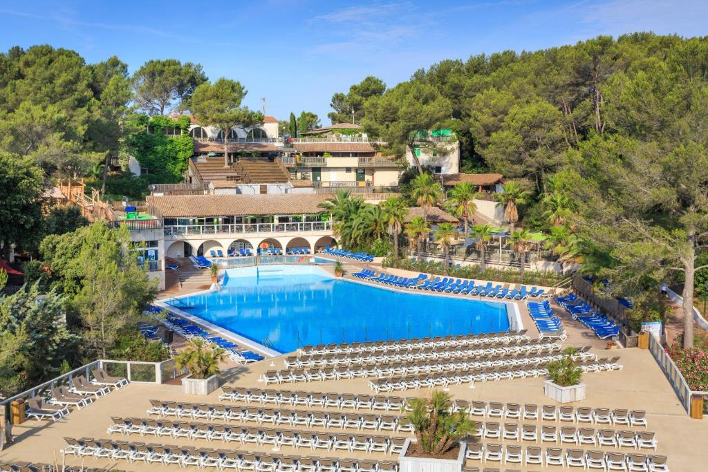 uma vista aérea de uma piscina do resort com cadeiras em Frantheor Fréjus 5 étoiles em Fréjus