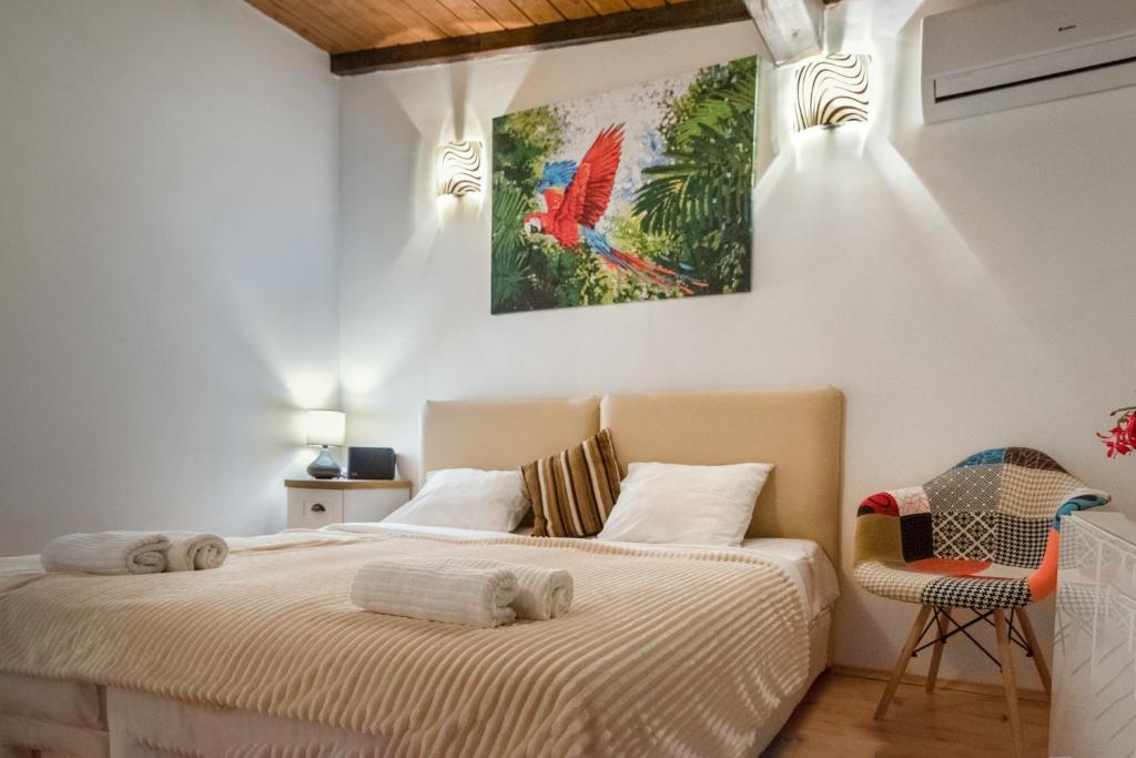 een slaapkamer met een bed met een vogelschilderij aan de muur bij The White House Sofia in Sofia