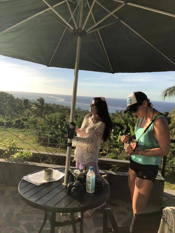 two women standing under an umbrella on a table at Saipan Skyline Designers Hotel in Saipan