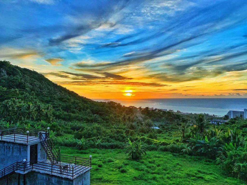 a sunset over the ocean from a hill at Saipan Skyline Designers Hotel in Saipan