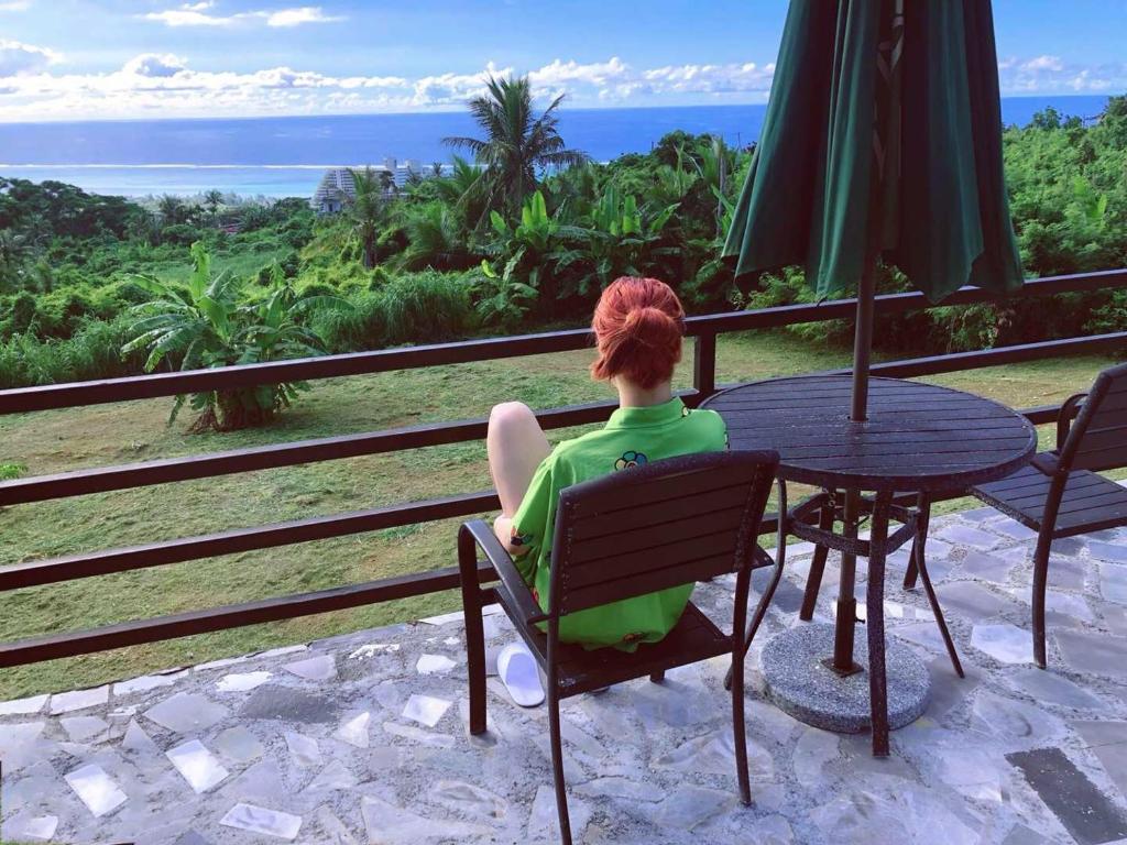 a woman sitting at a table looking out at the ocean at Saipan Skyline Designers Hotel in Saipan