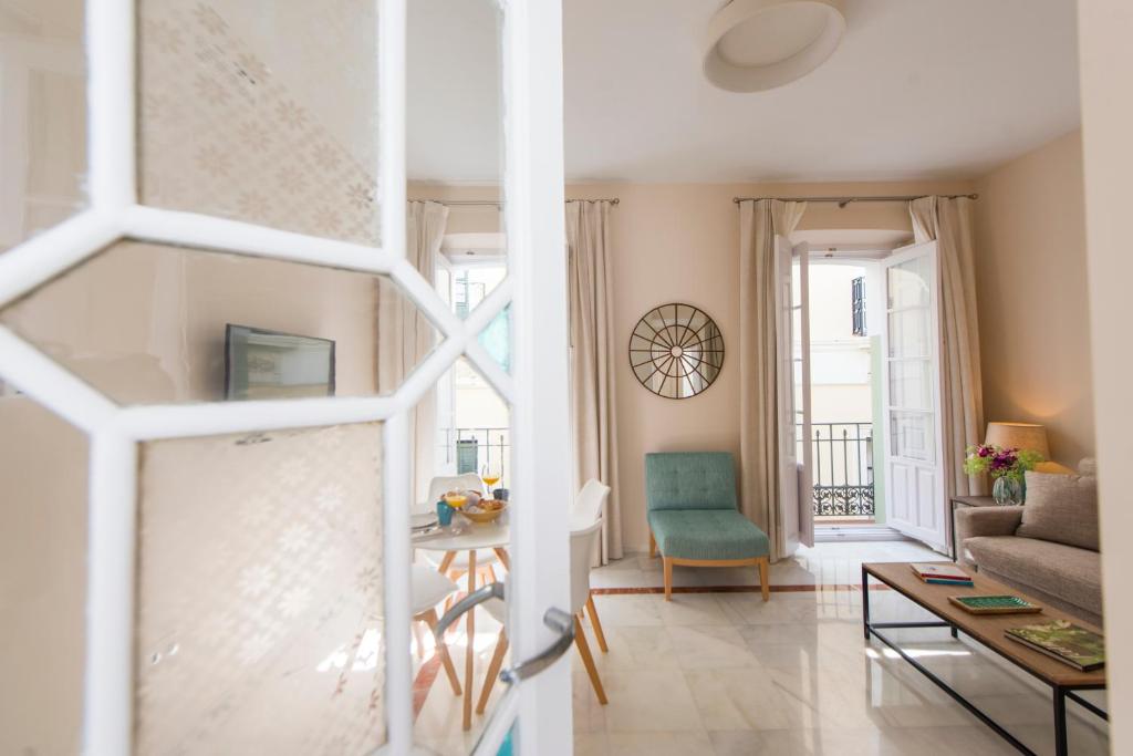 a living room filled with furniture and a window at Céntriko Apartments - Quintero 40 in Seville