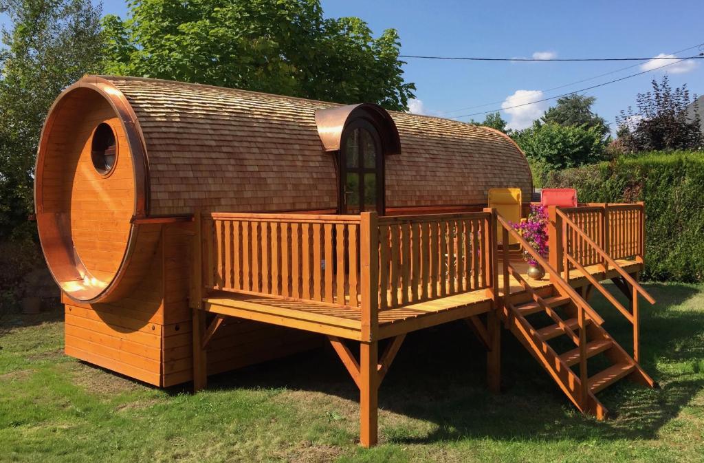 a wooden play house with a staircase in the grass at Gîte Chais Catherine in Amboise