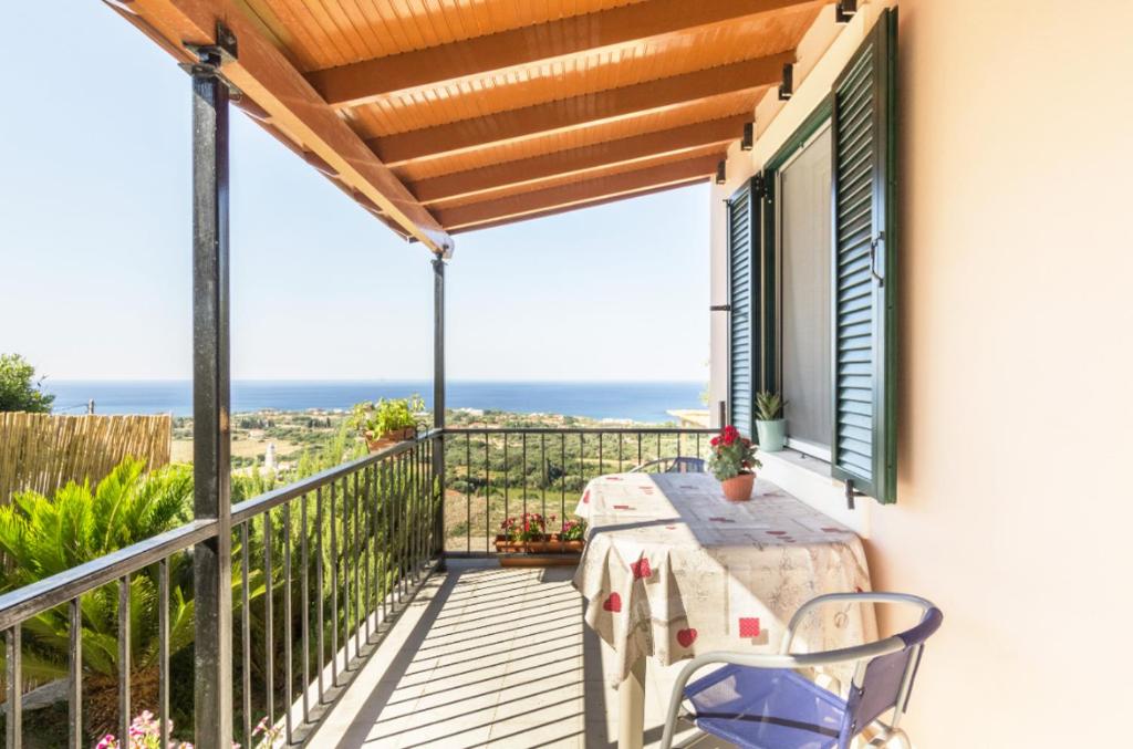 een balkon met een tafel en uitzicht op de oceaan bij Mema's great view Kefalonia in Svoronata