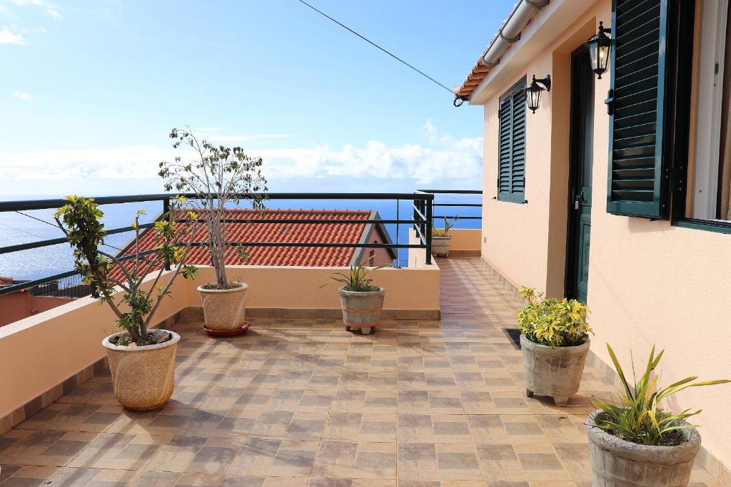 a balcony with potted plants on a building at Casa Bela Vista in Ribeira Brava