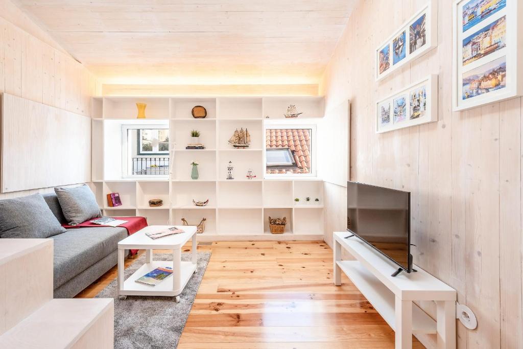 a living room with a couch and a tv at GuestReady - Beco do Garcês Apartment in Lisbon