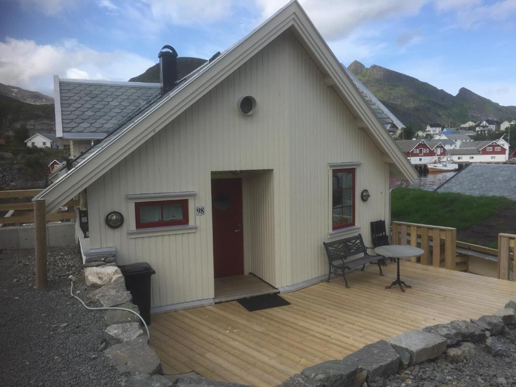 Casa blanca pequeña con terraza de madera en Astabrygga en Sørvågen