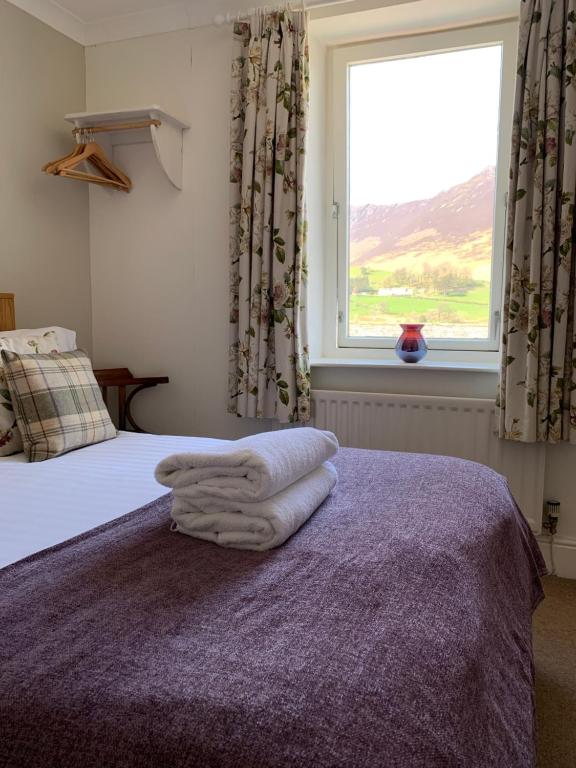 a bedroom with a bed with a large window at Littletown Farm Guest House in Keswick