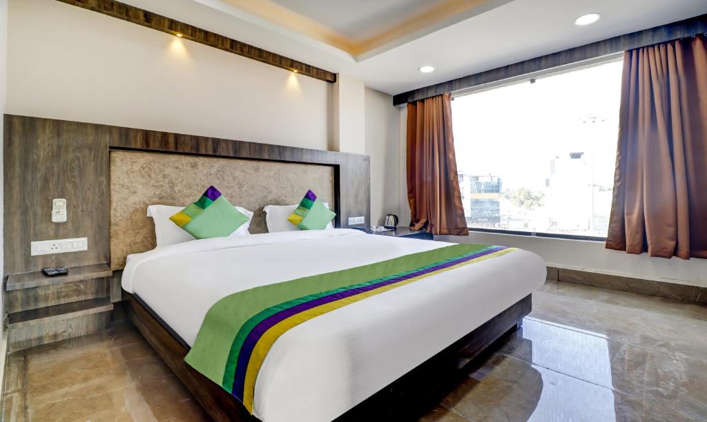 a large bed in a room with a large window at Hotel Bikalal, Bikaner in Bikaner