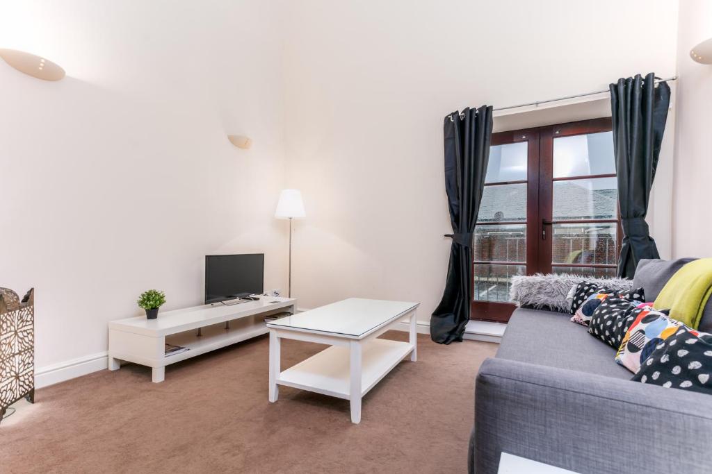 a living room with a couch and a tv at Elliot Suite No 1 - Donnini Apartments in Ayr