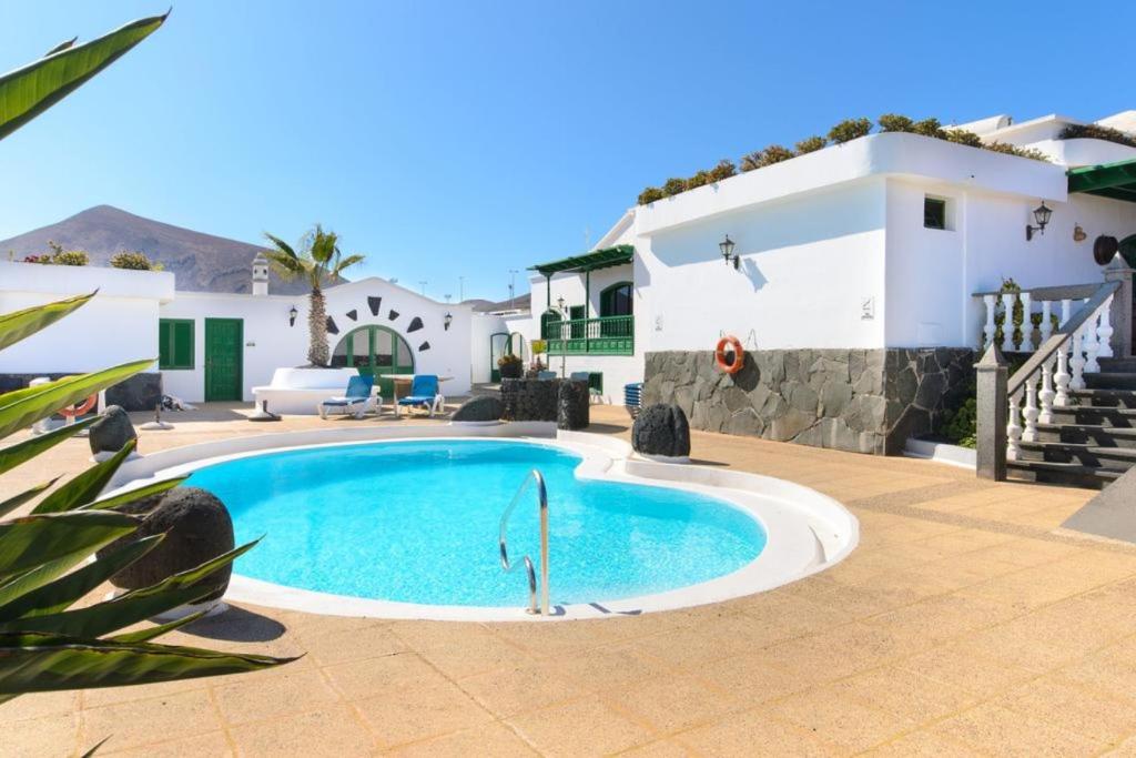 a villa with a swimming pool in front of a house at HOTEL-FINCA Rural José Manuel 28pax in San Bartolomé