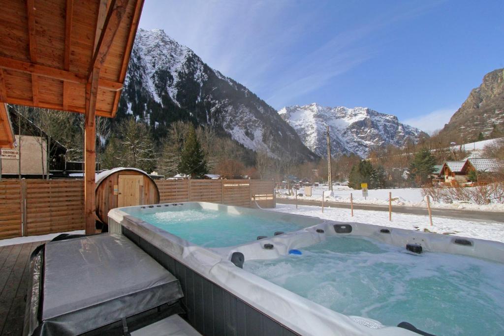 a jacuzzi tub with a snow covered mountain at L'Orchidée in Vénosc