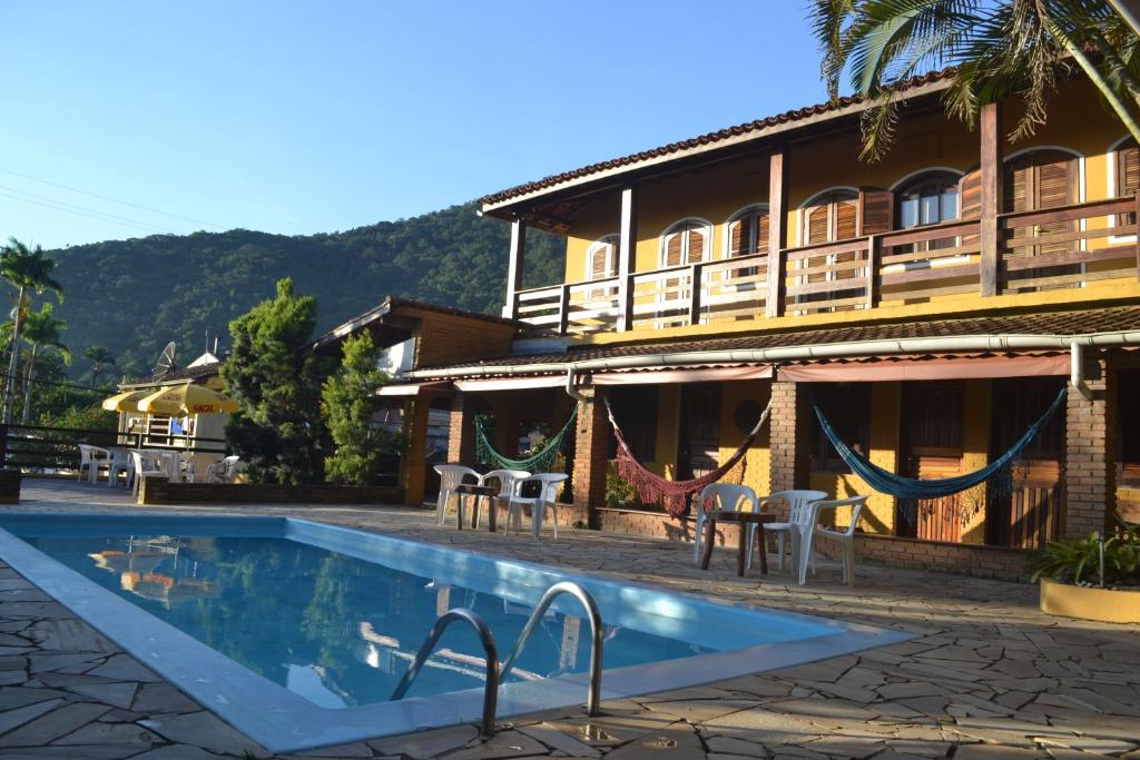 a hotel with a swimming pool in front of a building at Pousada Maanaim 2 in Ubatuba