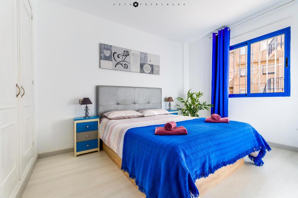 a bedroom with a bed with two red towels on it at BLUE SEA apartment in Torrevieja