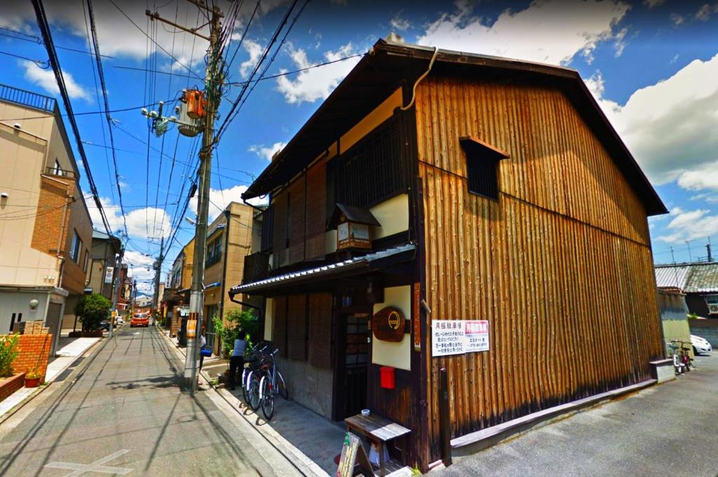 a building with a wooden facade on a street at Hostel Mundo in Kyoto