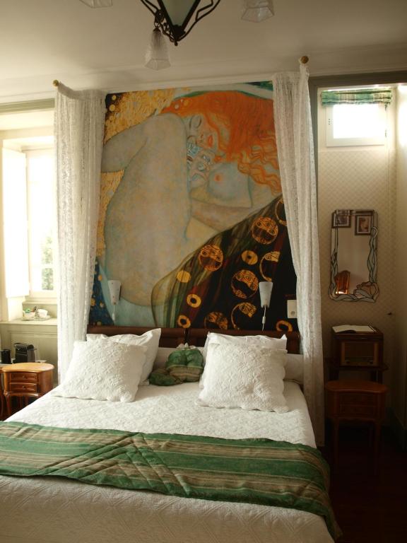 een slaapkamer met een bed met een schilderij aan de muur bij Villa Magnolia Parc - adults only in Montélimar