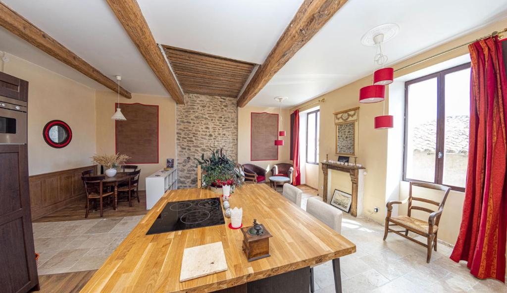 eine Küche und ein Wohnzimmer mit einem Holztisch in der Unterkunft La Comédie de Pézenas - Appartements in Pézenas
