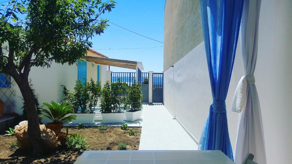 a courtyard with potted plants and a blue curtain at Casa vacanza il "Vignale" in Portopalo