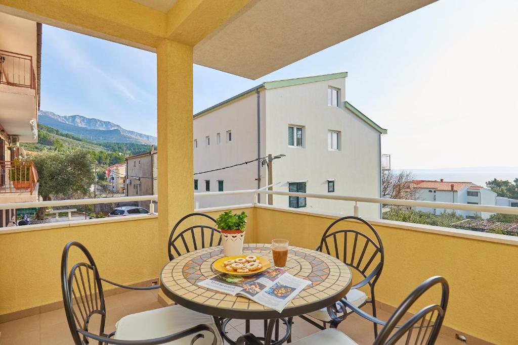 una mesa y sillas en un balcón con vistas en Apartments Zelic Tucepi, en Tučepi