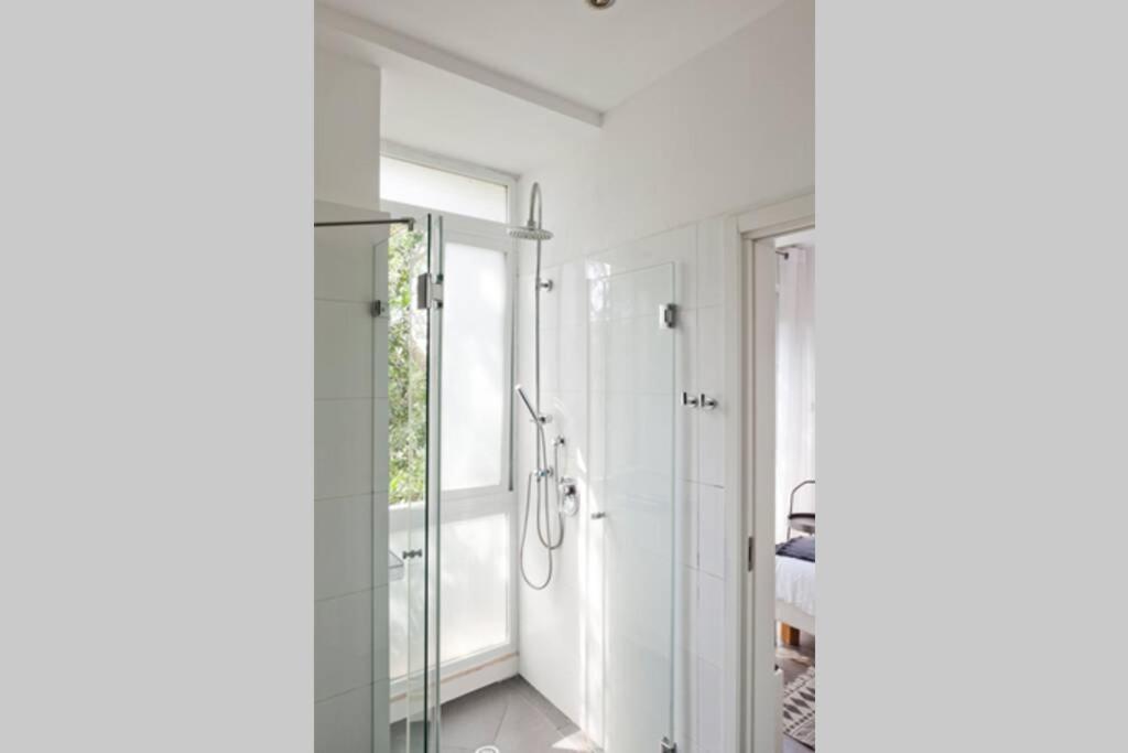 uma casa de banho branca com um chuveiro e uma janela em Gordon beach! 2 bedrooms great location em Tel Aviv