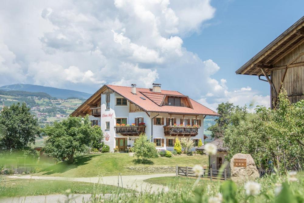 une grande maison blanche au sommet d'une colline dans l'établissement Ebenhof, à Collepietra