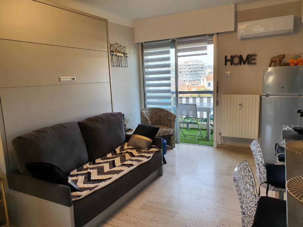 uma sala de estar com um sofá e um frigorífico em Méditerranée 2, by Welcome to Cannes em Cannes