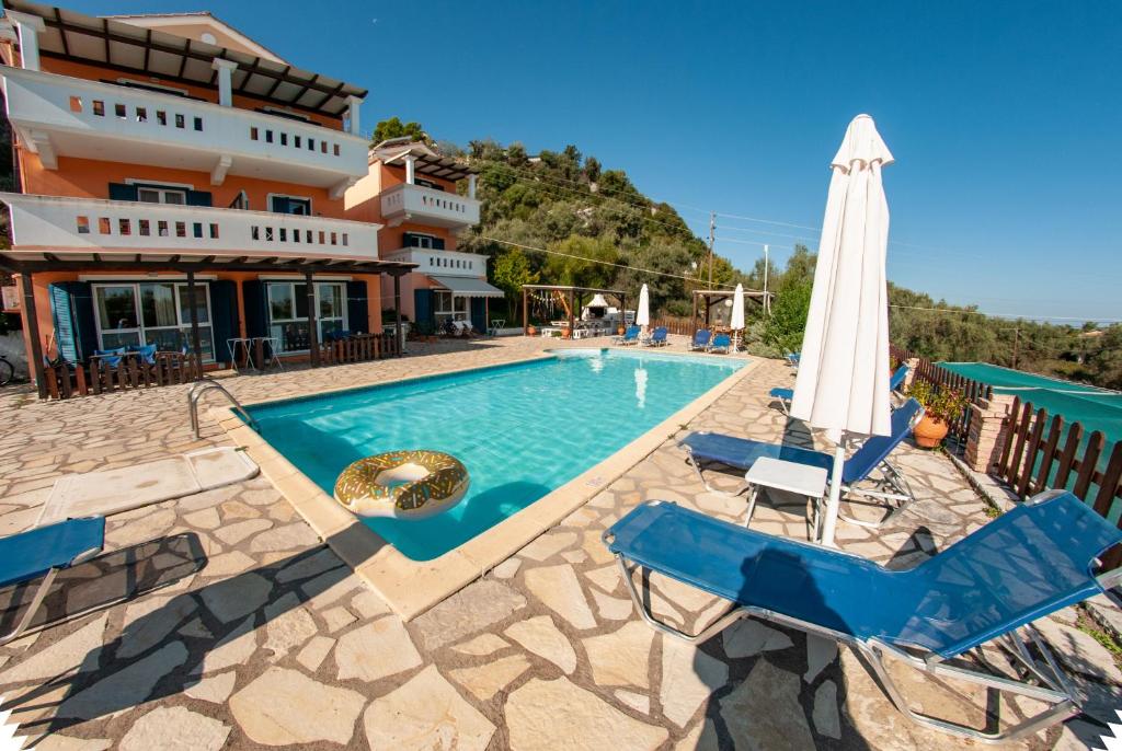 Villa con piscina con sillas y sombrilla en Ithaki Holidays, en Lefkada