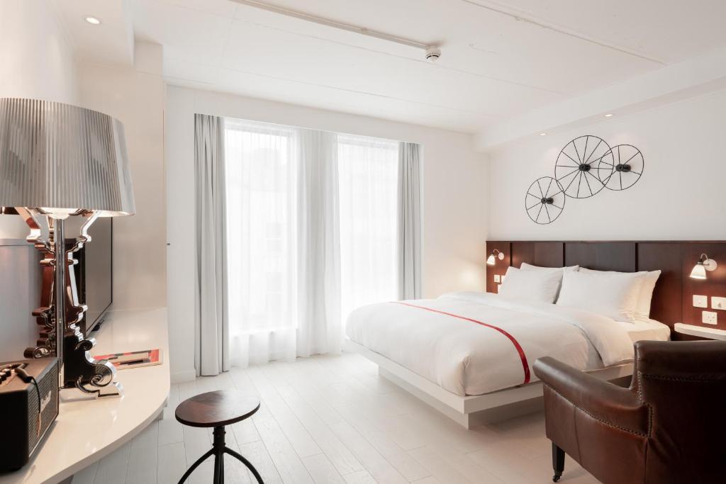 una camera con letto e scrivania con sedia di Ruby Lucy Hotel London a Londra