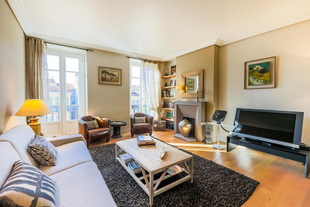 un salon avec un canapé blanc et une télévision dans l'établissement Vue Magenta AP4188 by Riviera Holiday Homes, à Nice