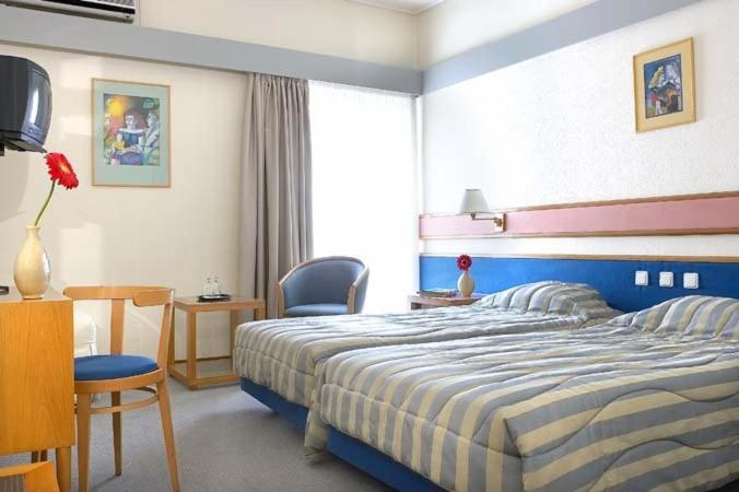 ラミアにあるHotel Samarasのベッドルーム1室(ベッド1台、デスク、椅子付)