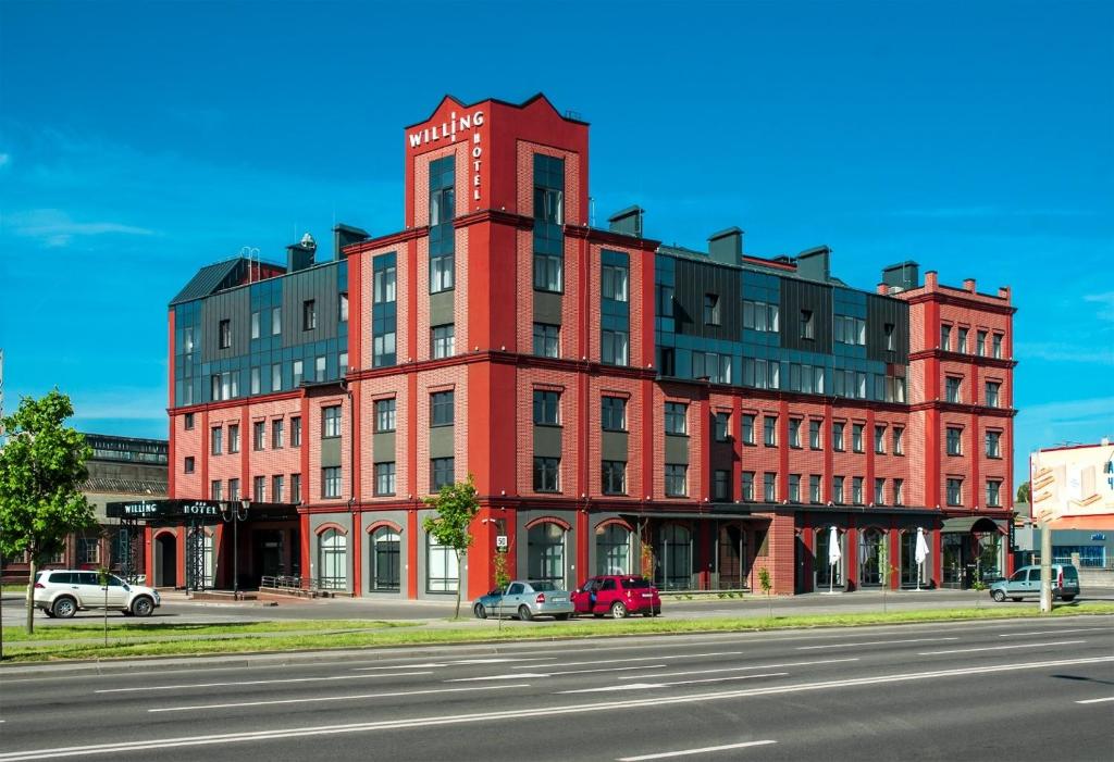 a red brick building on the corner of a street at Willing Hotel in Minsk