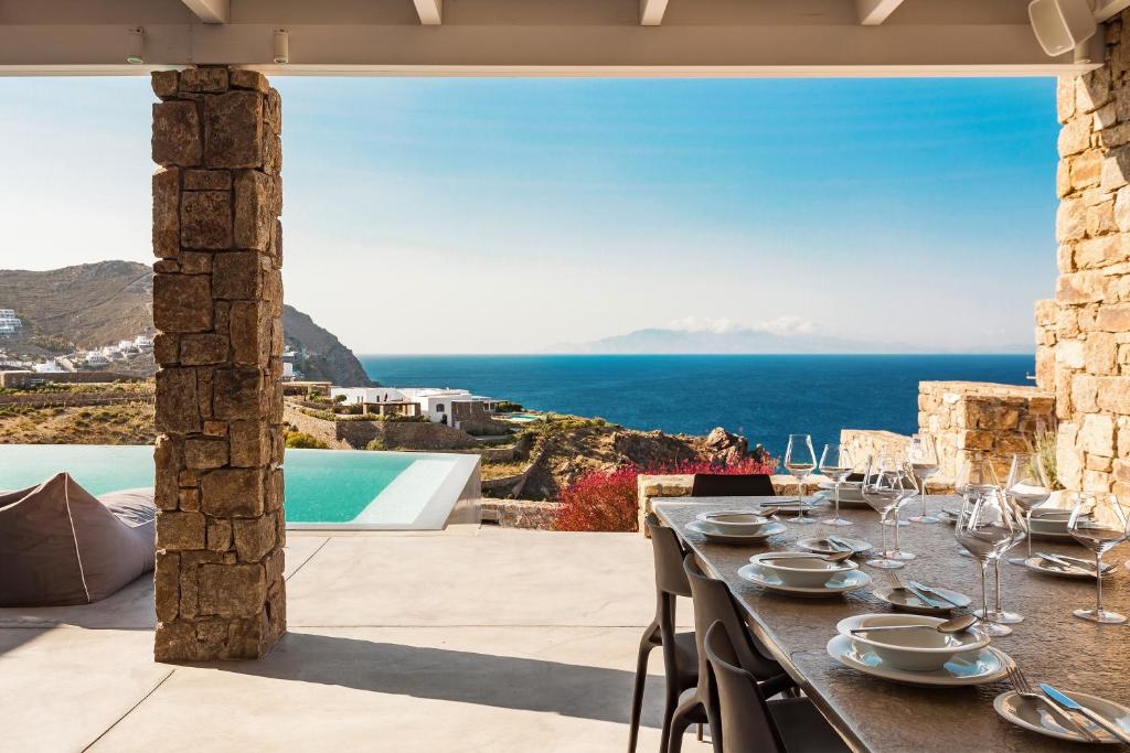 a dining table with a view of the ocean at Villa Apollo by Mykonos Luxury in Elia Beach