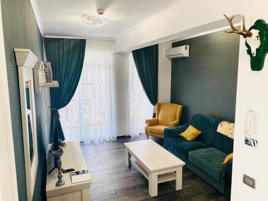 sala de estar con sofá verde y mesa en Olivia Home en Oradea