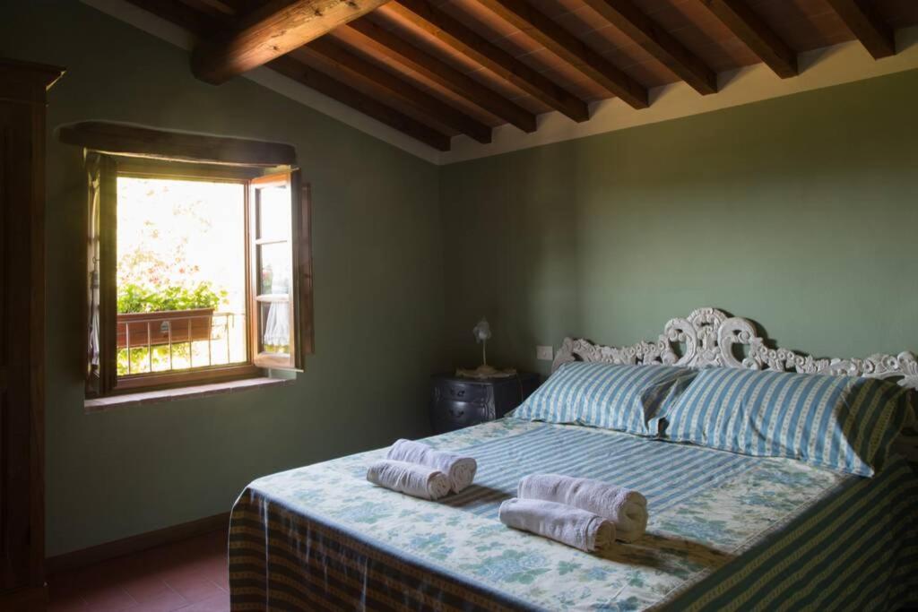 1 dormitorio con 1 cama con 2 toallas en Agriturismo Casariccio - Casa Dalia, en Bucine