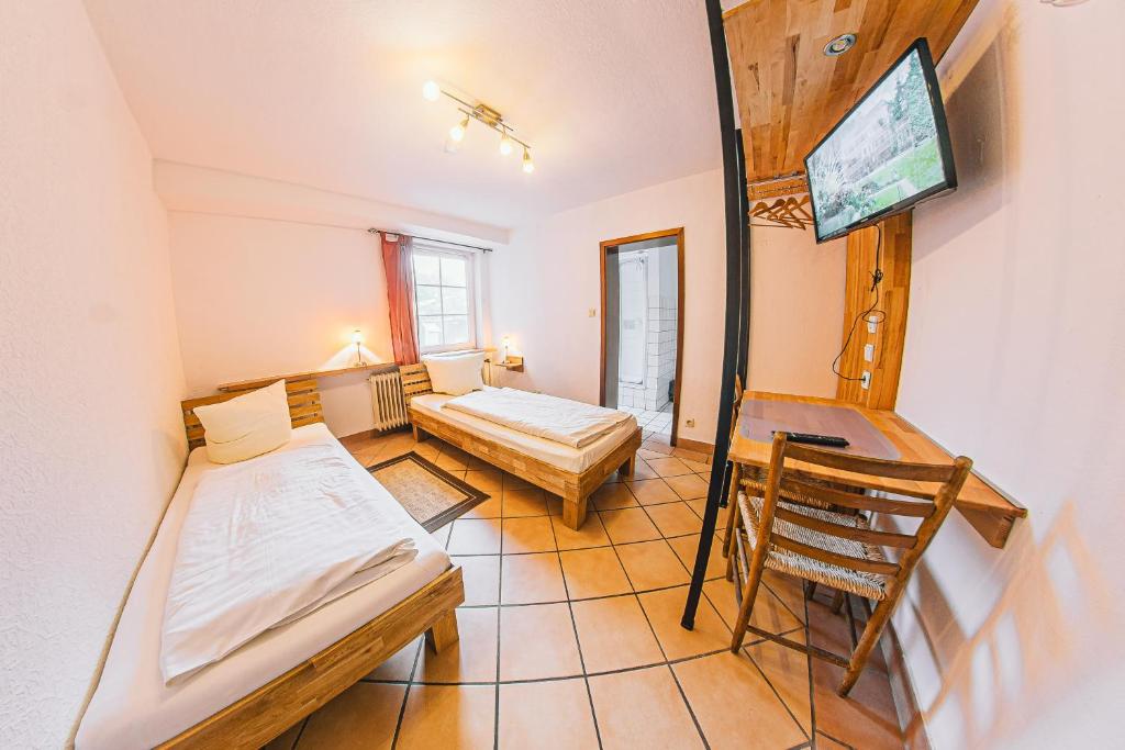 Habitación pequeña con 2 camas y escritorio. en Zum Eichenfrieden, en Rade