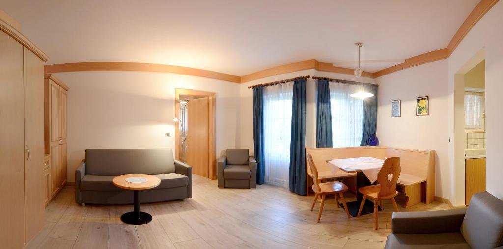 salon z kanapą i stołem w obiekcie Casa Roder by Garni Snaltnerhof w mieście Ortisei
