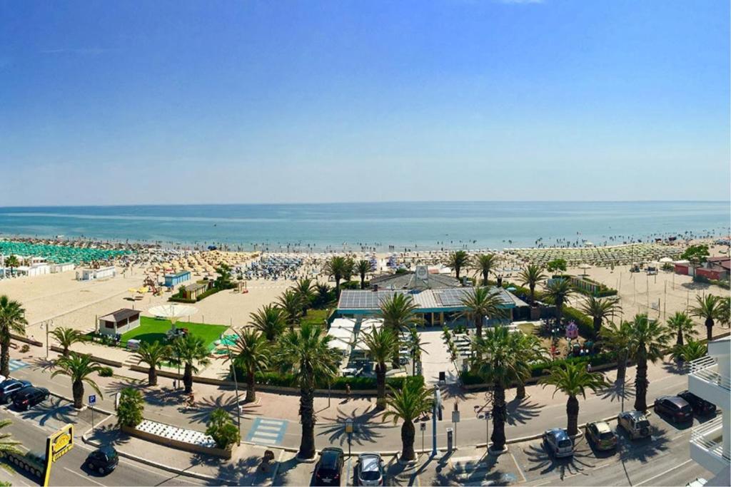 z góry widok na plażę z samochodami i palmami w obiekcie Appartamento Calipso - MyHo Casa w mieście Tortoreto Lido