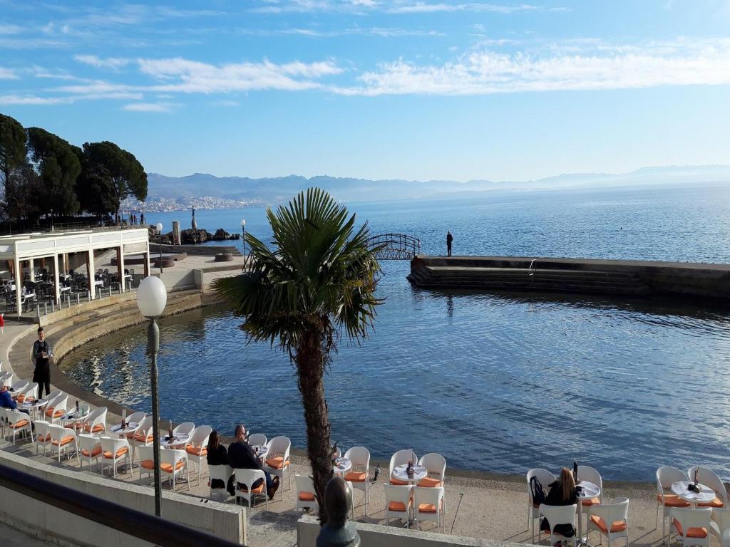 a group of people sitting in chairs by the water at Apartment Damir in Opatija