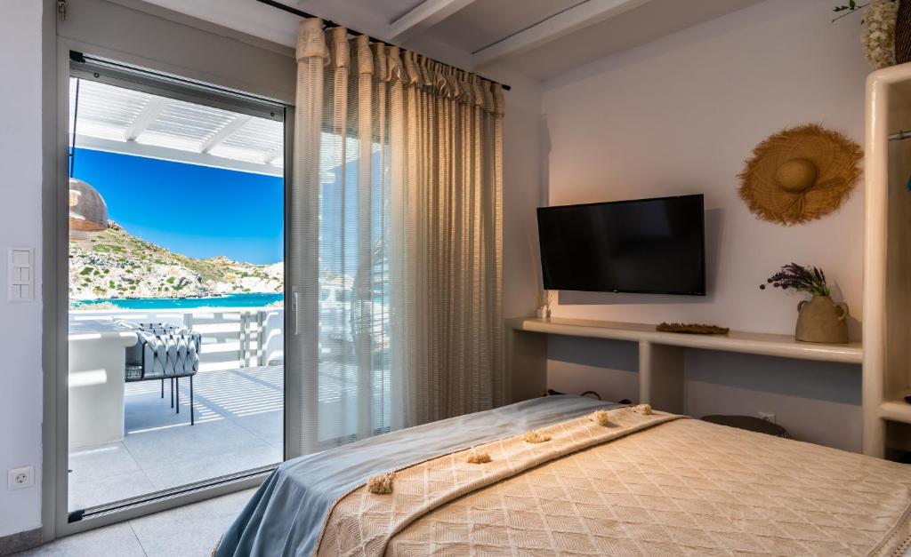 1 dormitorio con cama y vistas al océano en Luxurious stoudio in Mandrakia 1 en Mandrakia