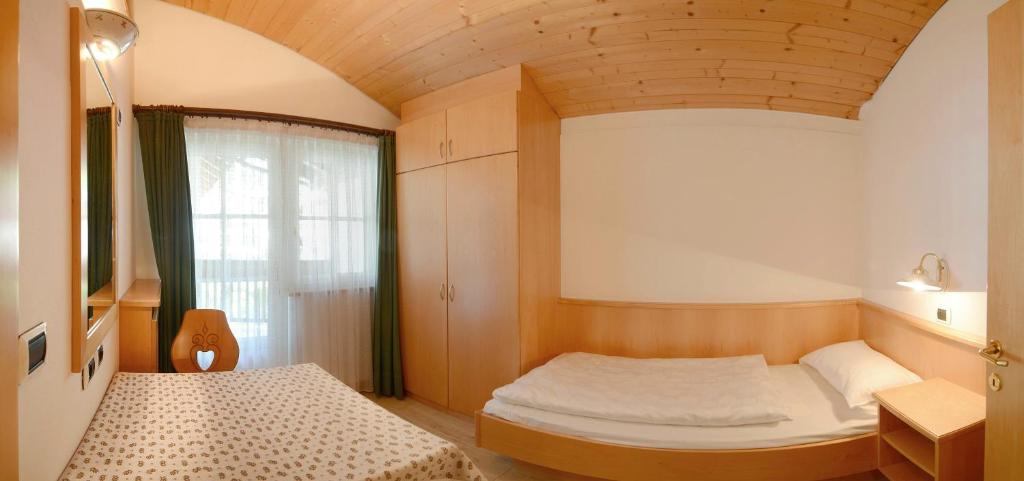 pokój z 2 łóżkami i oknem w obiekcie Casa Roder by Garni Snaltnerhof w mieście Ortisei