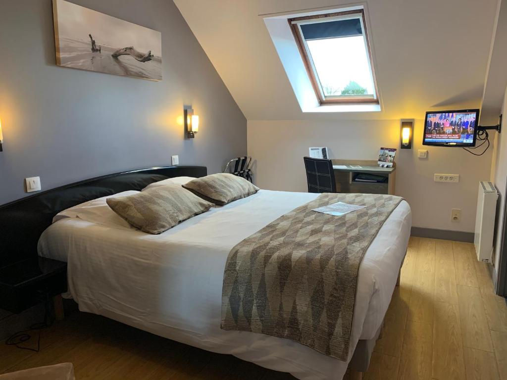 Postel nebo postele na pokoji v ubytování Hôtel Le Bayeux
